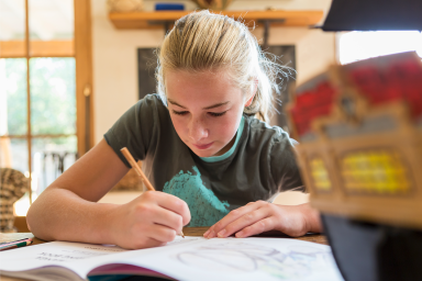 Photo of student in home office completing school work