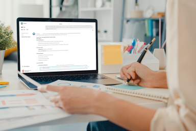 Photo of computer with EdChat and teacher taking notes