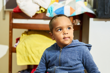 Photo of Aboriginal preschool student in blue jumper looking off into the distance