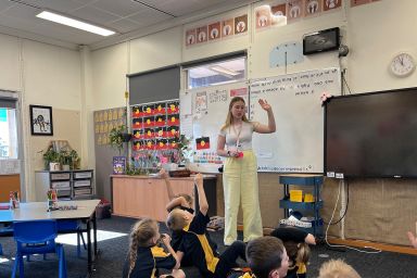 A teacher in front of a class teaching students