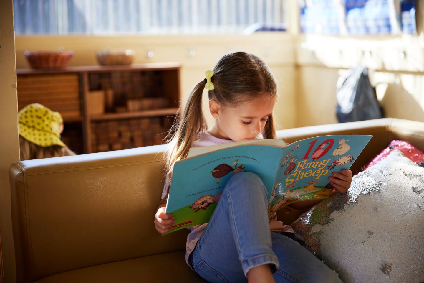 Preschooler sitting down and reading a book