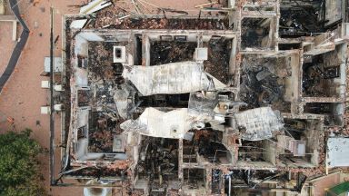 A school, that been damaged by a fire, debris and fallen infrastructure 