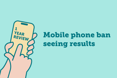 Graphic of hand holding up phone with text on phone screen saying "one year review" and text alongside which says "Mobile phone ban seeing positive results"