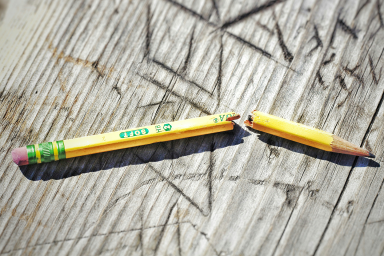 Photo of snapped lead pencil on wooden bench