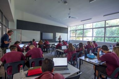 Students, sitting at desks in a classroom learning 