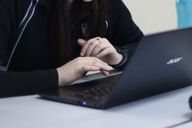 Two hands visible using a laptop computer