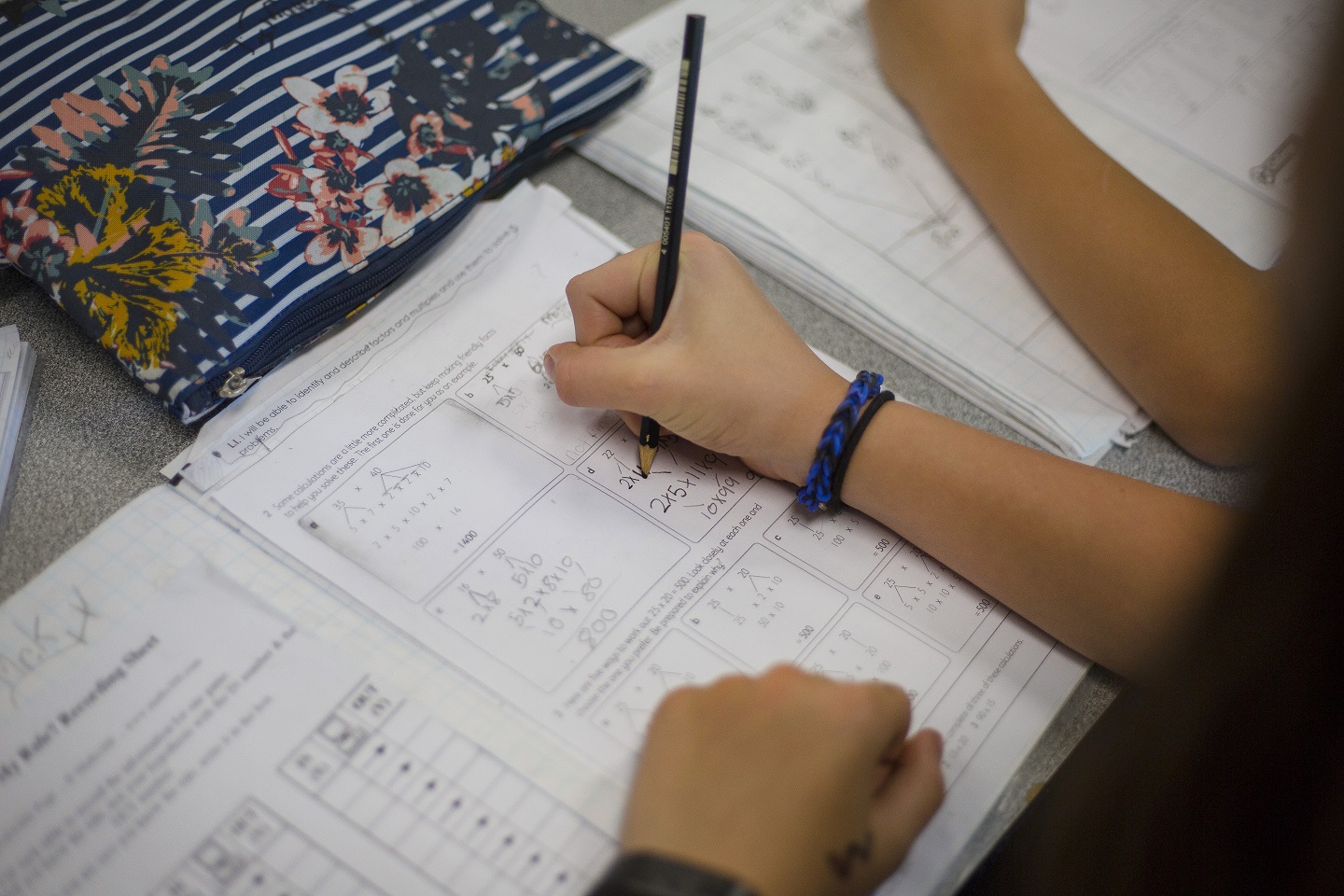 Student writing in a maths notebook