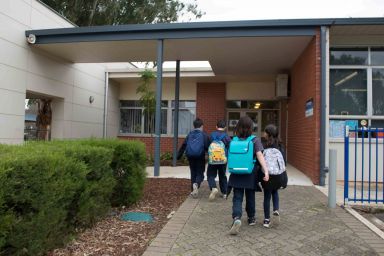 Students, in a school yard, walking into school