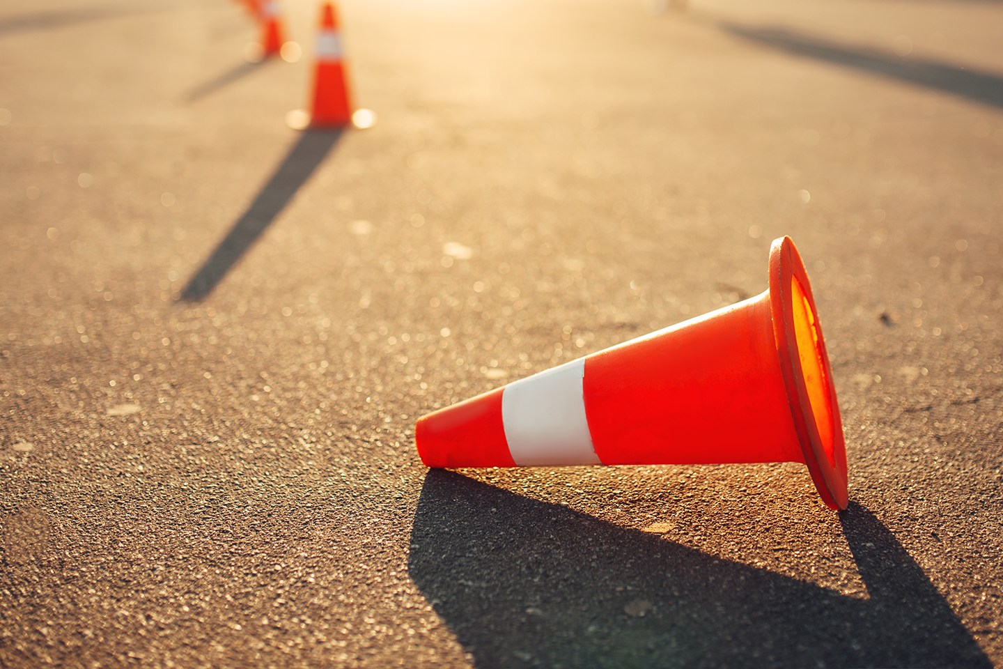 Photo of traffic cones on road with one cone knocked over