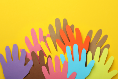 Collage of different colour paper hand cut outs on yellow background