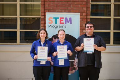 Three of the department's STEM scholarship recipients showing their certificates