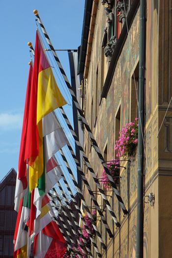 Nine different national flags hanging from a building