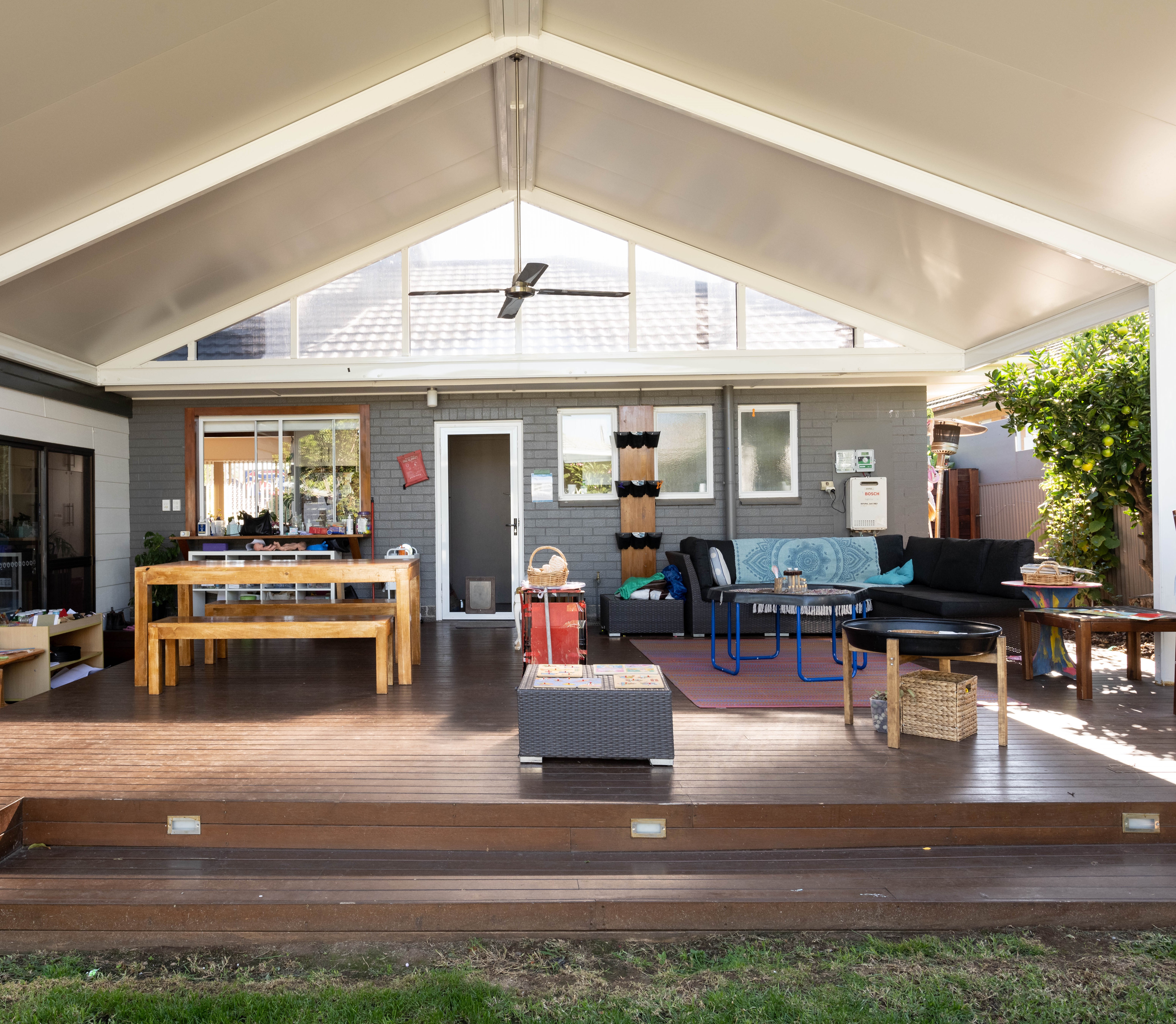 family day care setting – undercover outdoor decking area with chairs, tables and a modular couch