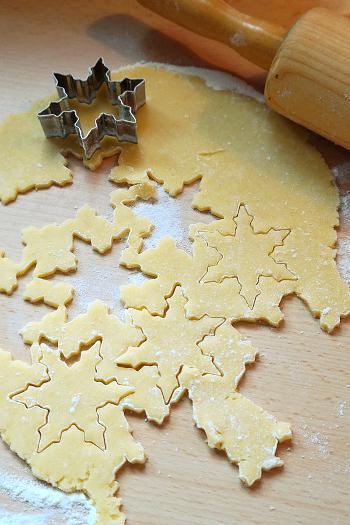 Cookie/biscuit dough that has been rolled flat with a rolling pin, and has had snow flake shaped cookies/biscuits cut out of it.