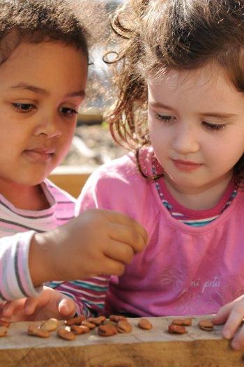 Two girls looking at seeds