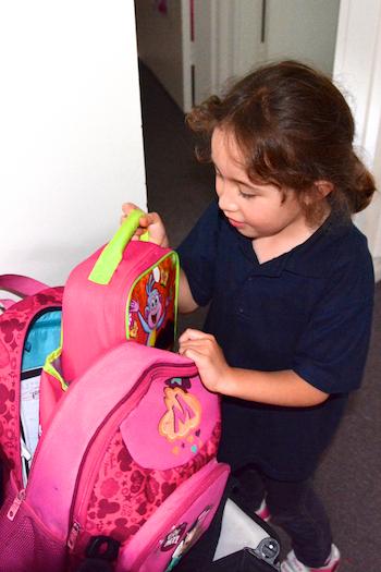 Young girl unpacking her school bag