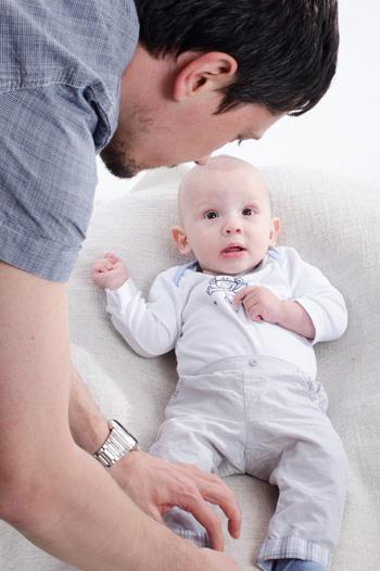 Male adult dressing baby