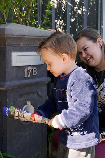 Young boy getting the junk mail out of the letter box