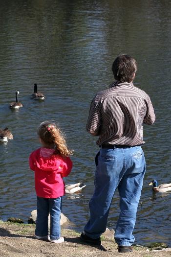 Father and daughter feeding the ducks