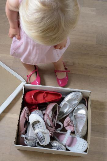 Young girl looking down at a box of shoes
