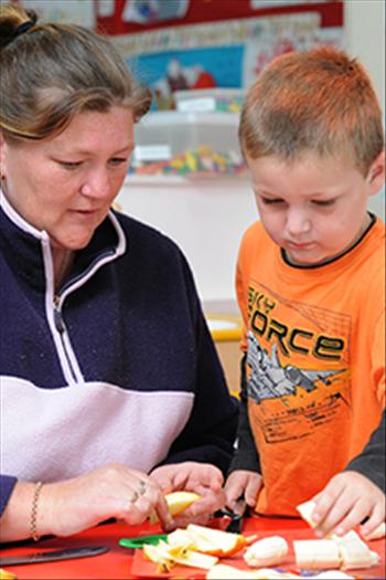 Child peeling a banana with an adult