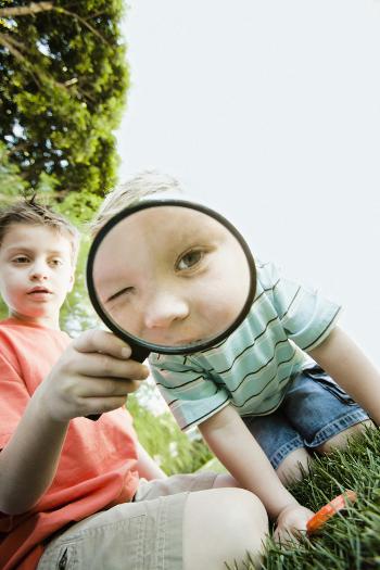 Boy looking through a magnifying glass