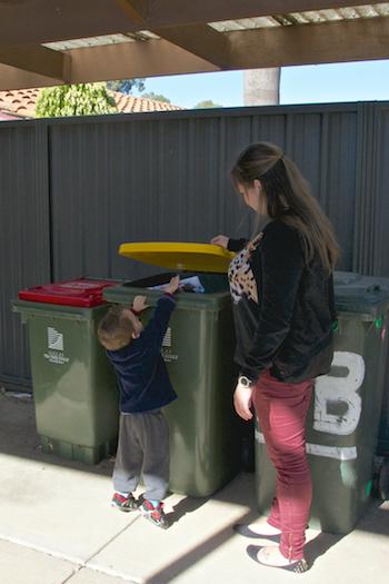 Boy puts paper in recycling bin