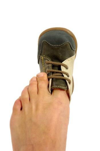 Children's shoe on an adult's toe