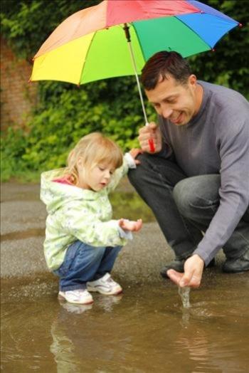 Young girl and father in a puddle on the street