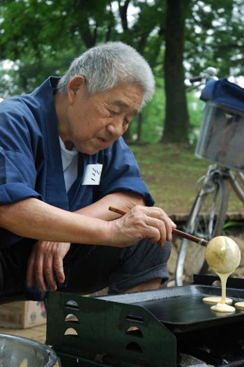 Man making pancakes on a outdoor frying pan