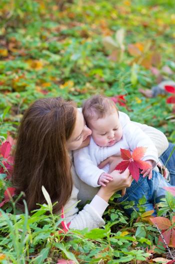 Mother laying on grass with baby