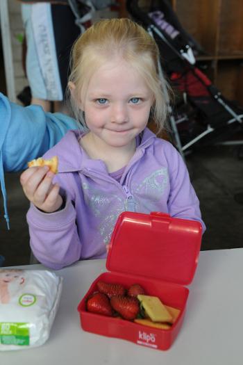 Young girl eating out of a lunch box