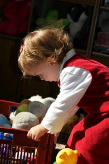 Young girl packing up her toys