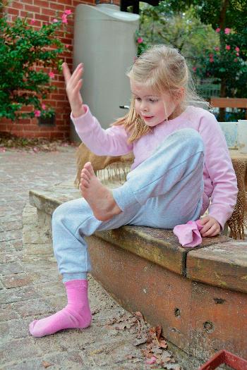 Young girl putting her shoes and socks on