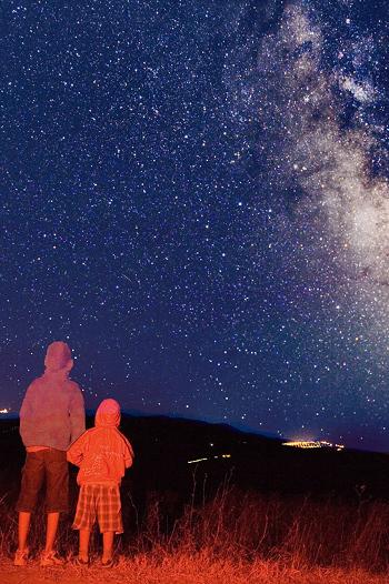 Adult and child looking up at the stars