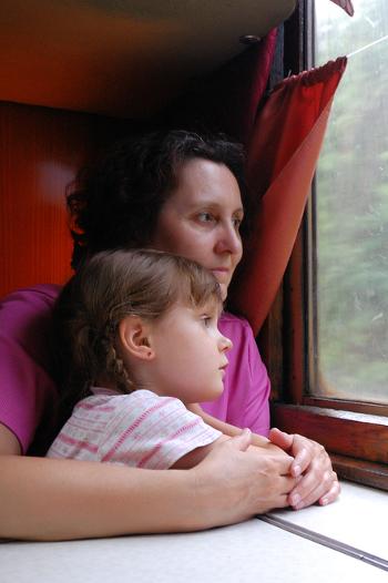 Mother and daughter looking out a train window