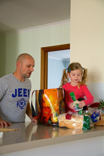 Father unpacking shopping bags with daughter