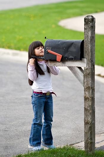 Young girl checking the letter box