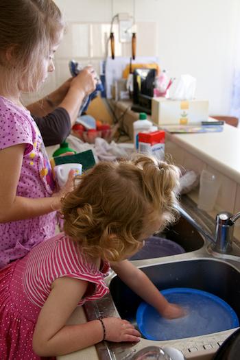 Two girl helping to wash the dishes