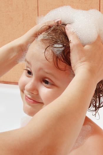 Child getting their hair washing in the bath