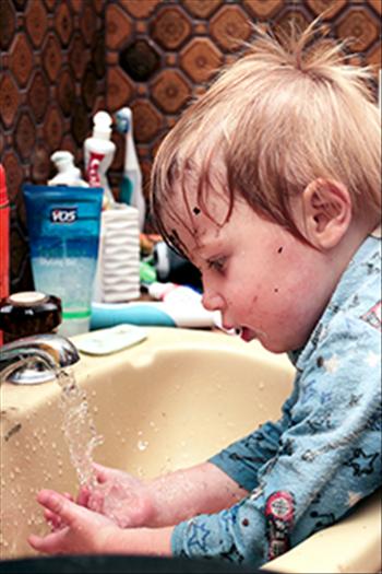 Young boy washing his hands