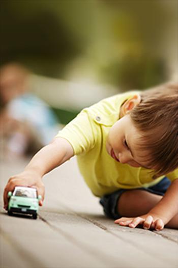 Young boy playing with a toy car