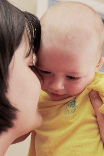 Baby being held up to mothers face