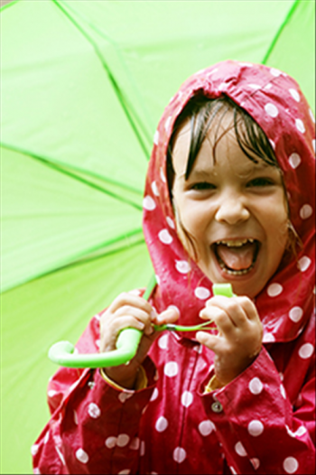 Young girl standing in the rain with an umbrella