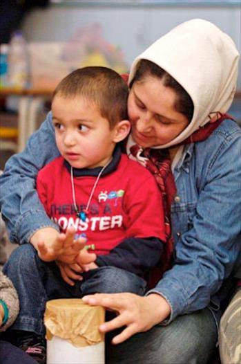 Mother and son making sounds on a home made drum