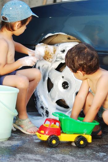 Two boys washing a blue car