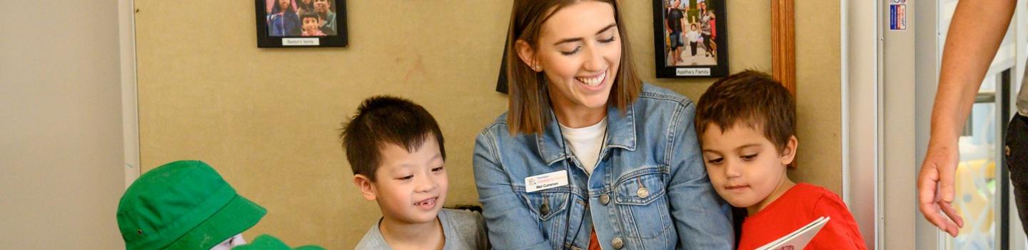 A preschool teacher reading to students