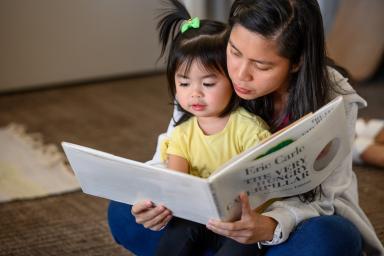 A woman reads a book with a child