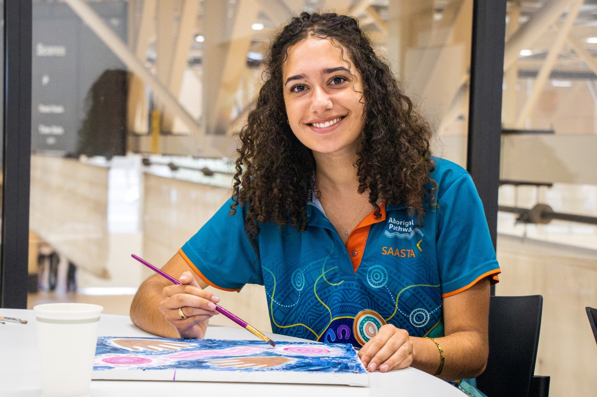 Student painting an Aboriginal artwork during a creative learning activity.