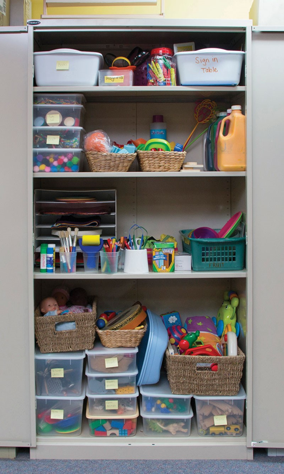 Almost everything you need to operate a successful playgroup can be housed in a standard metal lockable cupboard. An open metal locker displaying stored equipment and supplies like toys, paint. etc